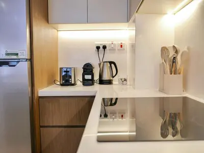 a kitchen counter with a coffee pot and utensils at Ambient 1BR Apartment On The Beach at 5 Star Resort in Dubai