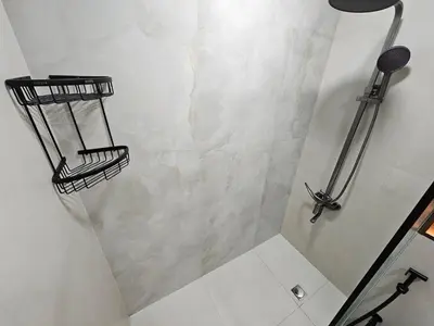 a bathroom with a shower with two baskets on the wall at Cozy Studio - Dubai Marina - 5 Min to Beach and Metro in Dubai