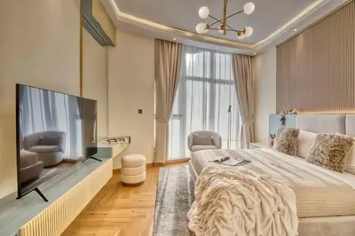 a bedroom with a large bed and a flat screen tv at The Smart Concierge - Avant in Dubai