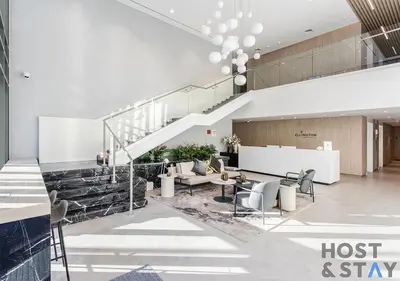 a lobby with a staircase and tables and chairs at Unique 1BR in Belgravia Square, JVC - Host & Stay in Dubai