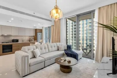 a living room with a white couch and a table at Apartments Beach Isle Tower, 1BR in Dubai