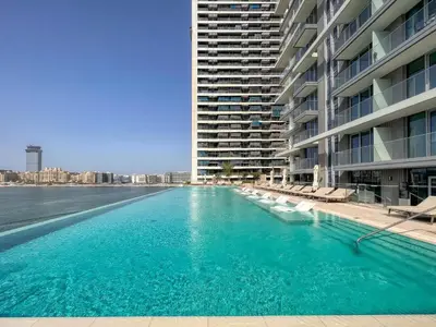 a large swimming pool next to a large building at Apartments Beach Isle Tower, 1BR in Dubai