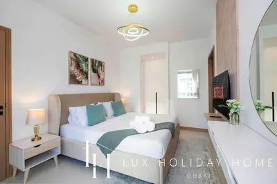 a white bedroom with a bed and a mirror at LUX The Vida Marina Residence 3 in Dubai
