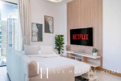 a living room with a white couch and a tv at LUX The Vida Marina Residence 3 in Dubai