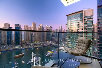 a chair on a balcony with a view of a city at LUX The Vida Marina Residence 3 in Dubai