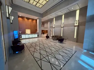 a lobby with chairs and a table in a building at Prestige Living 2BR with Full Burj Khalifa and Fountain View by Auberge in Dubai