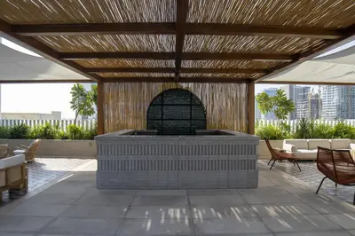 a large outdoor patio with a fireplace and chairs at Studio with Burj Khalifa View - Upside Living in Dubai