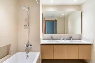 a bathroom with two sinks and a tub and a mirror at GuestReady - Sophistication Skyview Harbour in Dubai