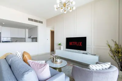 a living room with a blue couch and a tv at GuestReady - Sophistication Skyview Harbour in Dubai