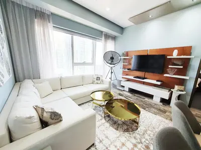 a living room with a white couch and a tv at Luxurious Escape meets Fendi Design in Iconic Building on Top Location in Dubai Marina in Dubai