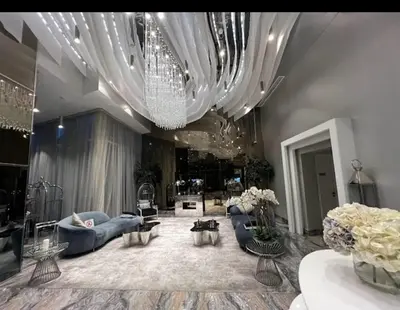 a large living room with blue couches and a chandelier at Luxurious Escape meets Fendi Design in Iconic Building on Top Location in Dubai Marina in Dubai