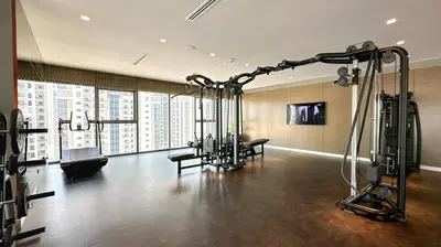 a gym with exercise equipment in a large building at High Floor 2 Bedroom Gem - Burj Khalifa Views in Dubai