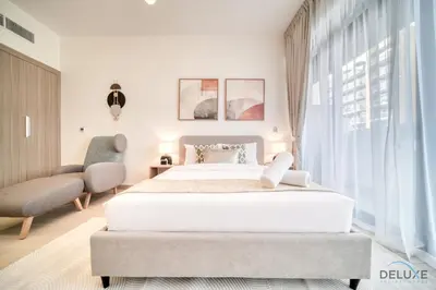 a white bedroom with a large bed and a window at Beautiful Studio at Azizi Riviera 17, Al Merkadh by Deluxe Holiday Homes in Dubai
