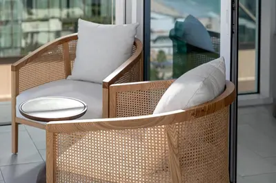 a wicker chair with a pillow and a table at 3Bed Private Beach - Belle vie à La Vie Dubai in Dubai