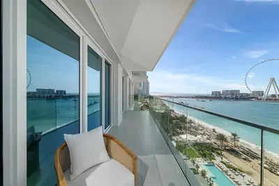a balcony with a chair and a view of the ocean at 3Bed Private Beach - Belle vie à La Vie Dubai in Dubai