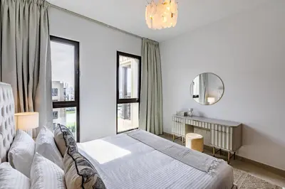 a white bedroom with a bed and a mirror at Apartment 1BDR in Madinat Jumeirah I Asayel 3 in Dubai