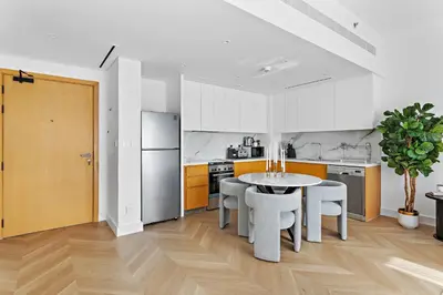 a kitchen with a table and chairs in a room at Elegant and Modern 1BR Apt in JBR with Beach Access in Dubai
