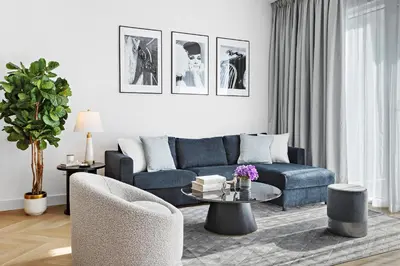 a living room with a blue couch and a table at Elegant and Modern 1BR Apt in JBR with Beach Access in Dubai