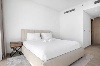 a bedroom with a white bed with a teddy bear on it at Amazing 2br with a lagoon view in Creek Harbour in Dubai