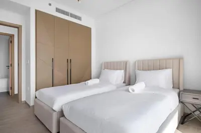 two beds sitting next to each other in a bedroom at Amazing 2br with a lagoon view in Creek Harbour in Dubai