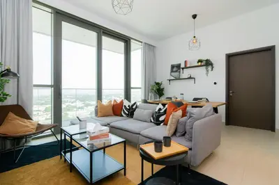 a living room with a couch and glass windows at Elite Escape Holiday Home - 1 BHK Getaway with Dubai Mall Access - 1502 in Dubai