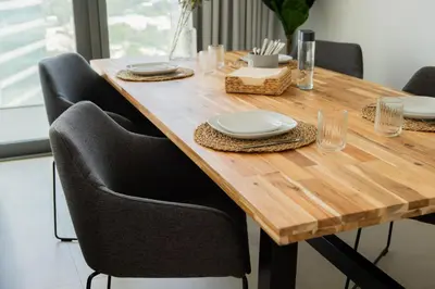 a wooden table with black chairs and a wooden table with plates at Elite Escape Holiday Home - 1 BHK Getaway with Dubai Mall Access - 1502 in Dubai