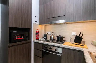 a kitchen with a stove and a microwave at Elite Escape Holiday Home - 1 BHK Getaway with Dubai Mall Access - 1502 in Dubai