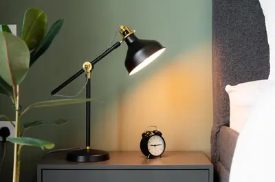 a desk with a lamp and an alarm clock on it at Elite Escape Holiday Home - 3 BHK Getaway with Burj Khalifa View and Dubai Mall Access - 1505 in Dubai