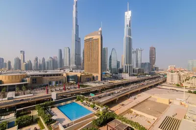 a view of a city with a pool in the foreground at Elite Escape Holiday Home - 3 BHK Getaway with Burj Khalifa View and Dubai Mall Access - 1505 in Dubai