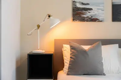a bedroom with a bed with a lamp and a pillow at Elite Escape Holiday Home - 3 BHK Getaway with Burj Khalifa View and Dubai Mall Access - 1505 in Dubai
