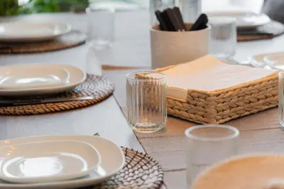 a table with plates and glasses on a table at Elite Escape Holiday Home - 3 BHK Getaway with Burj Khalifa View and Dubai Mall Access - 1505 in Dubai