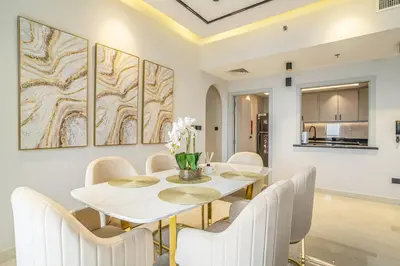 a dining room with a white table and chairs at New Arabian Shams 2 JBR Sea View in Dubai