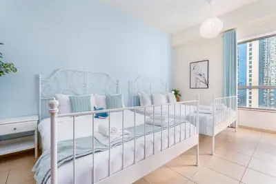 a white bedroom with two bunk beds and a window at 7 Beds / JBR / Sea, JBR Beach and Ain Dubai Views / 3 min walk from JBR Beach / Large Groups and Families / Ideal Vacation Location in Dubai