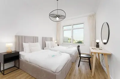 a bedroom with two beds and a desk and a mirror at Luxury Living w private beach and Burj AlArab view in Dubai