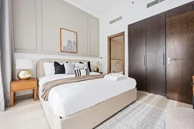 a bedroom with a large bed and a wooden cabinet at Silkhaus in Dubai Marina Heart, Opposite to Marina Mall in Dubai