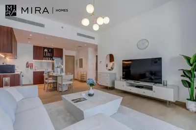 a living room with a white couch and a tv at Mira Holiday Homes - Newly 1 bedroom with sea view in Dubai