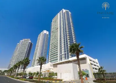 a group of tall buildings with palm trees in front at Damac Hills Carson C studio with full kitchenet - Ideal for monthly stay in Dubai