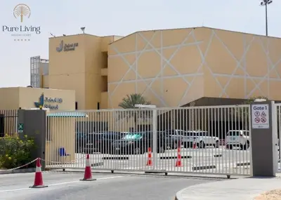 a fence with orange cones in front of a building at Damac Hills Carson C studio with full kitchenet - Ideal for monthly stay in Dubai