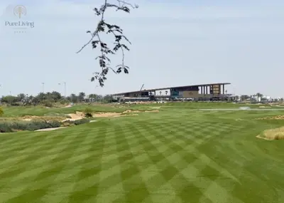 a view of a golf green with a building in the background at Damac Hills Carson C studio with full kitchenet - Ideal for monthly stay in Dubai