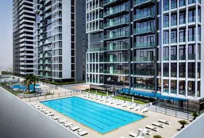 an overhead view of a swimming pool in front of tall buildings at HAVN - 2 Bedroom Apartment in Bloom Tower, JVC in Dubai