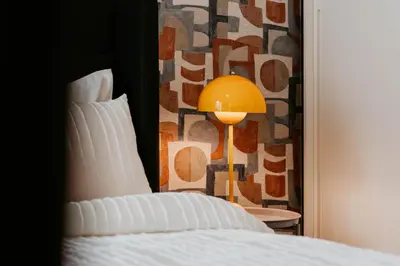 a bedroom with a bed and a yellow lamp at Coolest 1 BR in Dubai Hills close to the Park in Dubai
