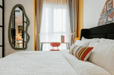 a bedroom with a large white bed and a mirror at Coolest 1 BR in Dubai Hills close to the Park in Dubai