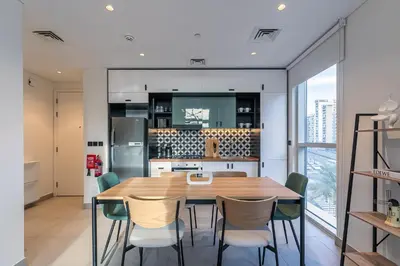 a kitchen and dining room with a wooden table and chairs at Upgraded Interior I Dubai Hills I City View I Socio Tower in Dubai