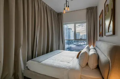 a bedroom with a bed and a large window at Upgraded Interior I Dubai Hills I City View I Socio Tower in Dubai