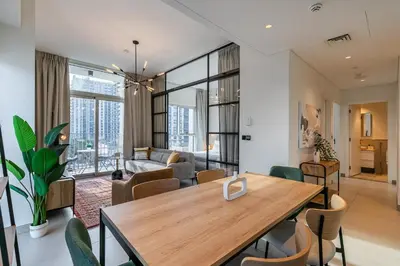 a living room with a wooden table and chairs at Upgraded Interior I Dubai Hills I City View I Socio Tower in Dubai