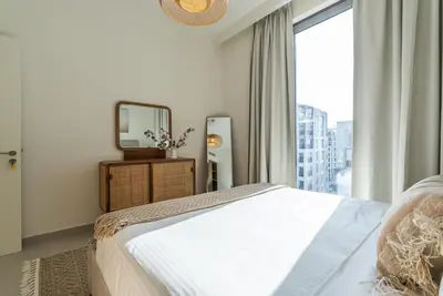 a bedroom with a bed and a mirror and a window at Coastal Vibe I 1BDR apartment in Creek Beach I Summer 2 in Dubai