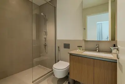 a bathroom with a shower and a toilet and a sink at Coastal Vibe I 1BDR apartment in Creek Beach I Summer 2 in Dubai