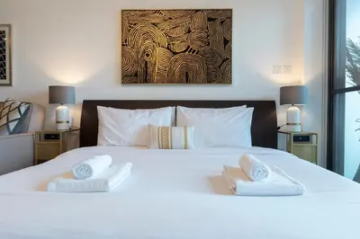a bedroom with a white bed with two towels at GuestReady Holiday Homes - Lux Studio with a View in Dubai