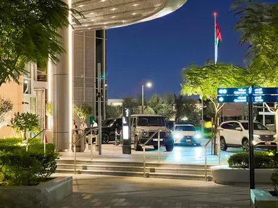 a building with cars parked in a parking lot at night at Downtown Luxury - Stunning Burj Khalifa & Sea View - 5 Minutes Walk to Dubai Mall in Dubai