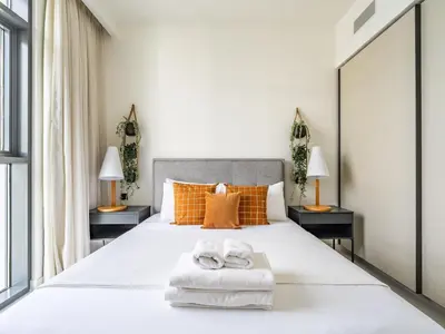 a bedroom with a large white bed with two towels at Sea-Front Unique Retreat With Balcony in Marina in Dubai